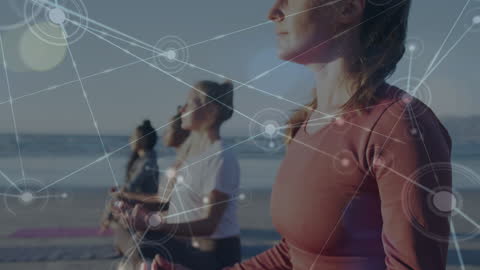 Diverse Women Meditating On Beach with Digital Network Overlay
