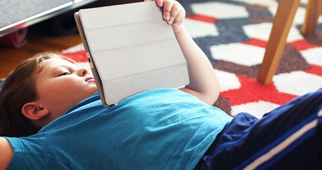 Child Lying on Carpet Using Tablet for Entertainment - Download Free Stock Images Pikwizard.com