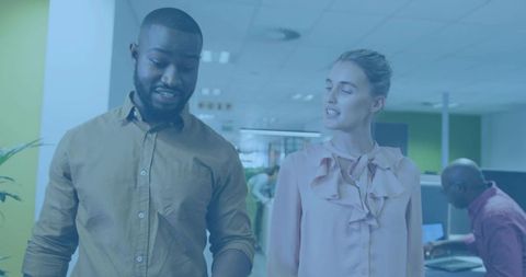Walking coworkers chatting and collaborating in modern open-plan office corridor teamwork