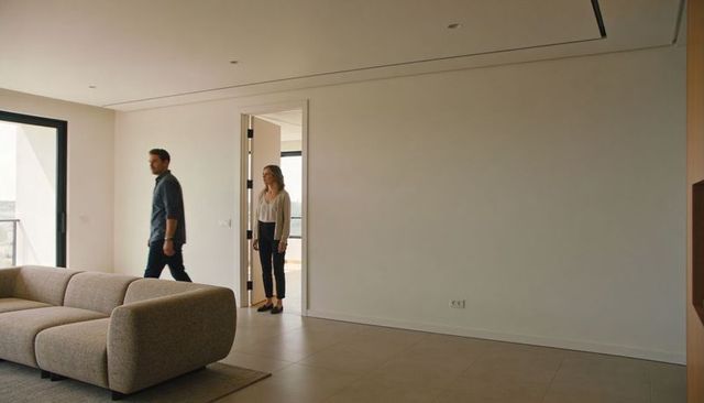 Walking couple exploring minimal modern apartment with spacious neutral living room