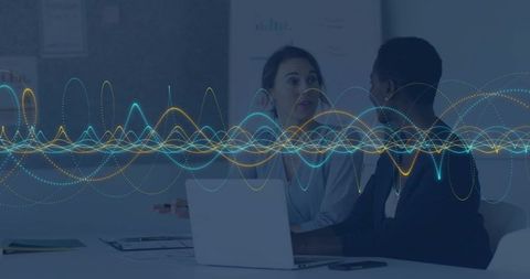 Business colleagues collaborating over laptop with digital waveform overlay for analytics