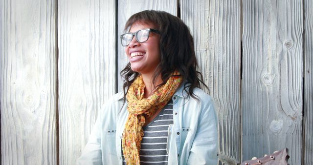 Smiling Woman Wearing Glasses and Scarf Against Wooden Wall - Download Free Stock Images Pikwizard.com