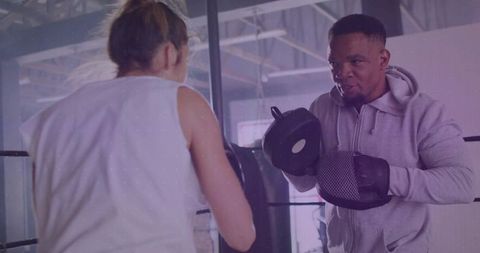 Boxing trainer guiding athlete in ring for dynamic workout