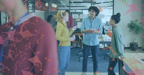 Young professionals collaborating and sharing ideas in open-plan office during coffee break