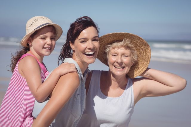 Portrait of cheerful multi-generation family at beach during sunny day
