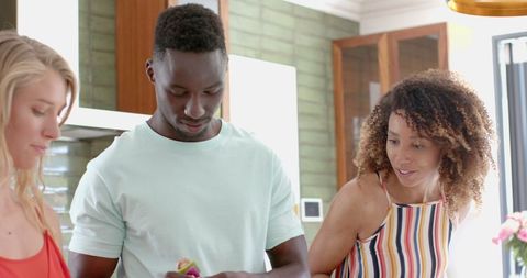 Multicultural friends cooking together in bright modern kitchen