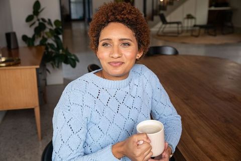 Thoughtful woman enjoying coffee break in modern lounge