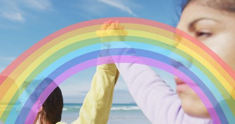 Empowering women on beach with colorful rainbow symbolism