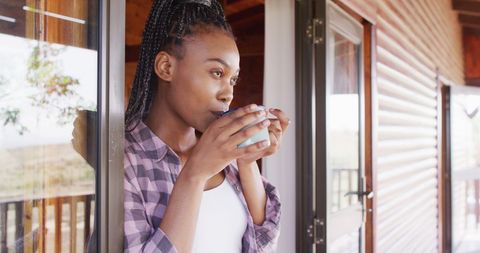 Woman Relaxing with Morning Coffee on Cabin Porch