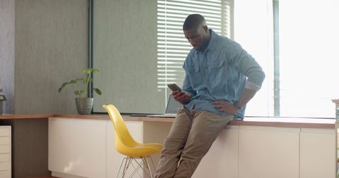 Professional Man Using Smartphone in Minimal Office