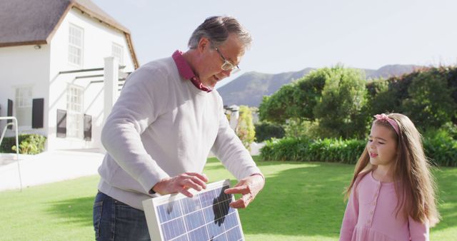 Grandfather and Granddaughter Working with Solar Panel in Garden - Download Free Stock Images Pikwizard.com