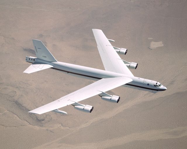 The B-52H Stratofortress is shown flying high above a barren desert landscape, highlighting its extensive wingspan and impressive engineering. This aircraft, used extensively by NASA for test flights, is a staple in strategic long-range bombing missions. Ideal for illustrating aerospace technology, military aircraft design, or NASA flight tests.