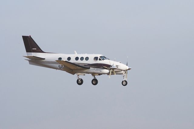 Twin-engine private aircraft flying in a clear blue sky. This photo can be used for articles, websites and advertisements related to aviation, private air travel, aircraft manufacturing, and the airline industry.