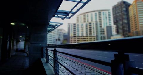 Urban walkway with glass canopy and city buildings