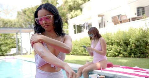 Young Women Applying Sunscreen by Poolside on Sunny Day - Download Free Stock Images Pikwizard.com