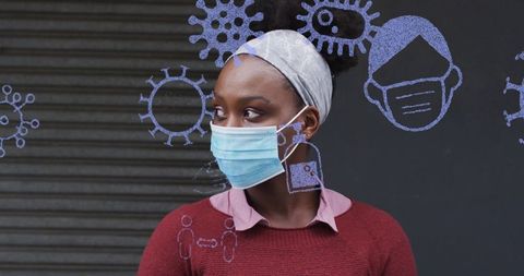 Woman wearing surgical mask and headwrap looking sideways with virus doodles on shutter