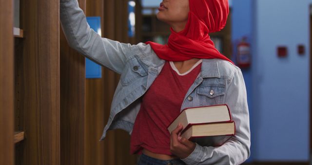 Female Student in Red Hijab Searching Books in Library - Download Free Stock Images Pikwizard.com