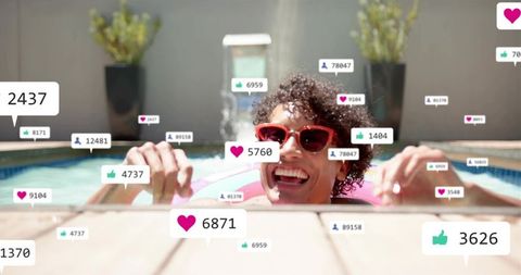 Smiling man relaxing in backyard pool on pink float with social media like icons and likes