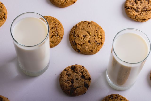 High angle view of milk glasses with cookies over white background, copy space. unaltered, food, drink, studio shot and healthy eating.