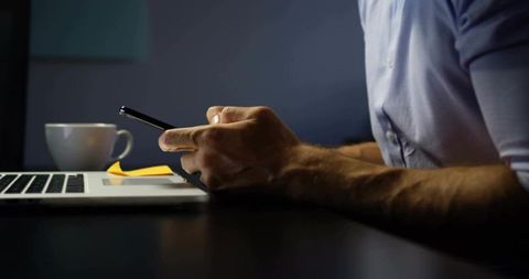 Businessman Checking Smartphone at Modern Workstation Late at Night