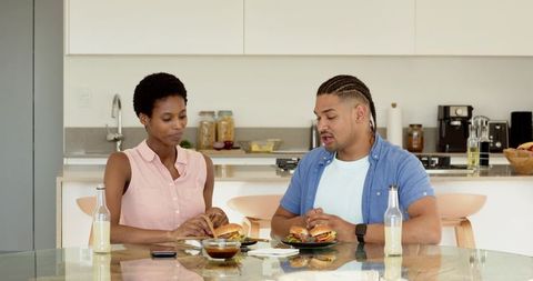 Diverse Friends Enjoying Burgers in Modern Kitchen Setting