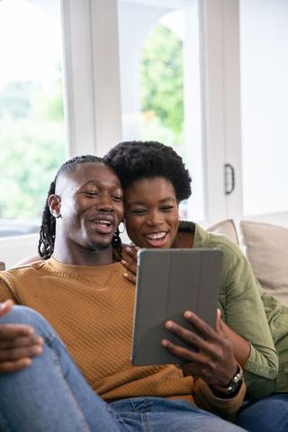 Happy African American Couple Enjoy Dove's Cozy Afternoon Indoors