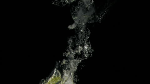 Pear Splashing into Water Against Black Background