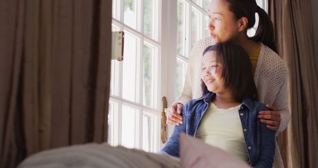 Image of thoughtful asian mother and daughter looking outside window. Family, motherhood, relations and spending quality time together concept digitally generated image.