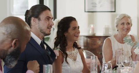 Bride and groom smiling with guests at elegant indoor wedding