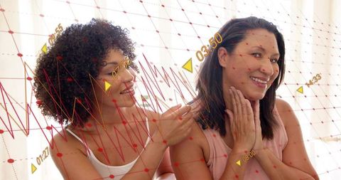 Sharing tender bedside moment, smiling women connecting through touch and warmth