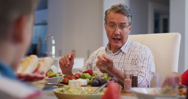 Middle-aged man giving speech at family dinner table - Download Free Stock Images Pikwizard.com