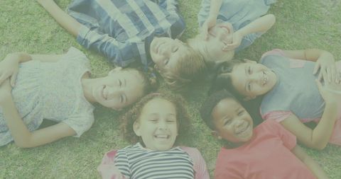 Joyful Children Lying on Grass Forming a Circle