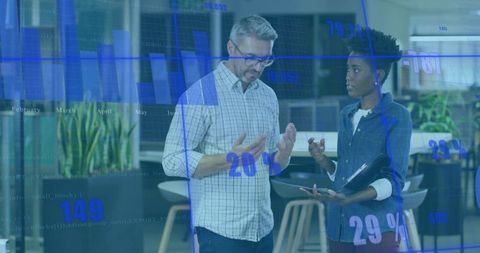 Two Professionals Discussing Financial Data with Overlayed Blue Graphs
