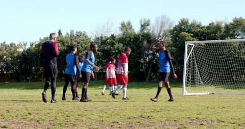 Diverse Soccer Team Walking Across Community Park Pitch