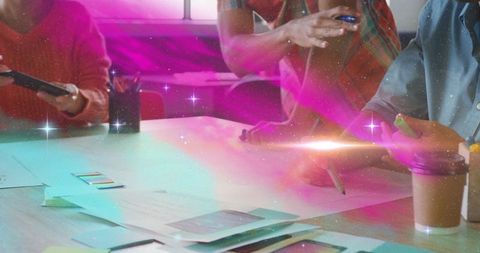Collaborating team exploring color palettes and sketching design concepts with neon glow