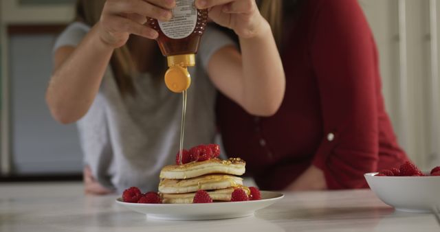 Mother and Child Pouring Honey on Pancakes with Raspberries - Download Free Stock Images Pikwizard.com