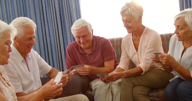 Group of senior friends playing cards at home 