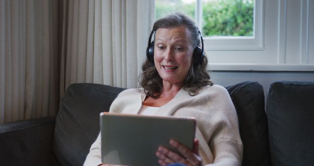 Senior Woman Smiling and Using Tablet with Headphones - Download Free Stock Images Pikwizard.com