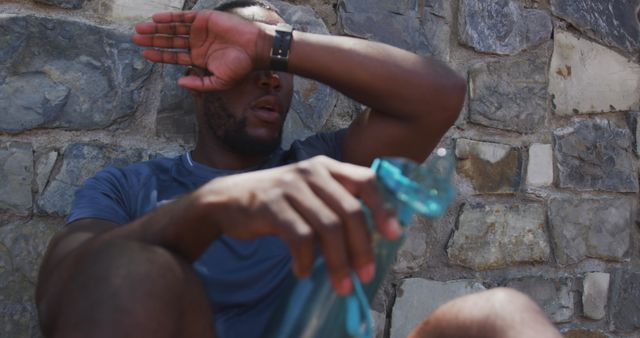 Exhausted Athlete Resting on Stone Wall After Intense Workout - Download Free Stock Images Pikwizard.com