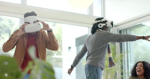 African American Friends Experiencing VR Gaming in Sunlit Modern Living Room