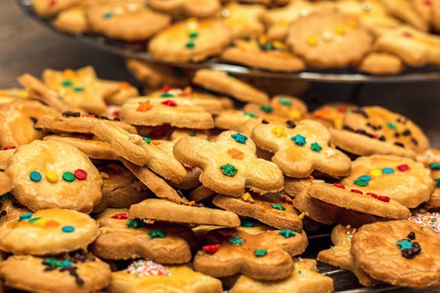A pile of homemade Christmas cookies decorated with colorful sprinkles, perfect for holiday celebrations and festive gatherings. Ideal for use in holiday-themed advertisements, recipe blogs, and festive event promotions.