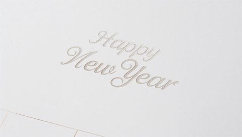 Embossed happy new year metallic script on ivory textured card minimalist stationery