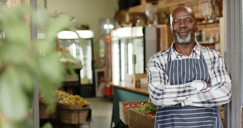 Proud african american shopkeeper standing at organic store entrance