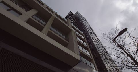 Low angle perspective of modern building against cloudy sky