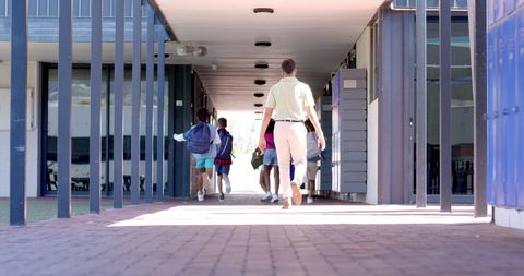 Teacher Leading Diverse Students Across School Corridor - Download Free Stock Images Pikwizard.com