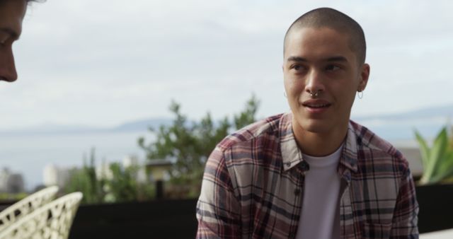 Young Man with Piercings Engaging in Conversation Outdoors - Download Free Stock Images Pikwizard.com