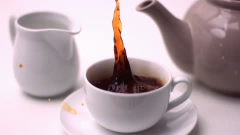 Slow Motion Tea Pour with Sugar Cube Dropping in White Cup