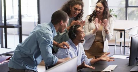 Diverse Team Celebrating Success at Office Desk