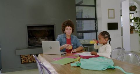Mother and Daughter Studying Together at Home with Juice Refreshment