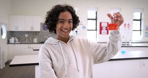Curious Schoolboy Experimenting with Chemicals in Laboratory